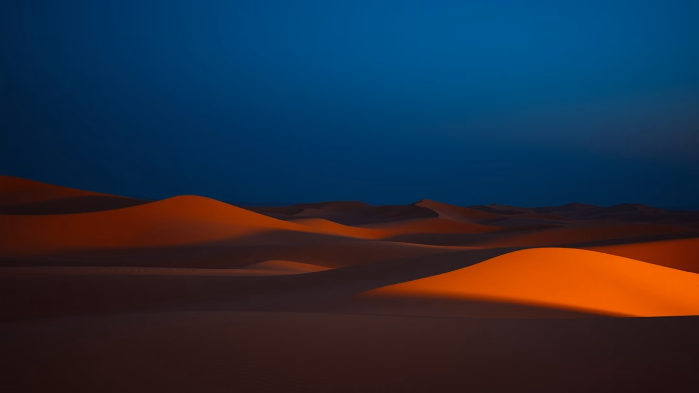 A vast, abstract desert landscape at twilight, where golden sand dunes meet a deep indigo sky, ethereal and infinite.