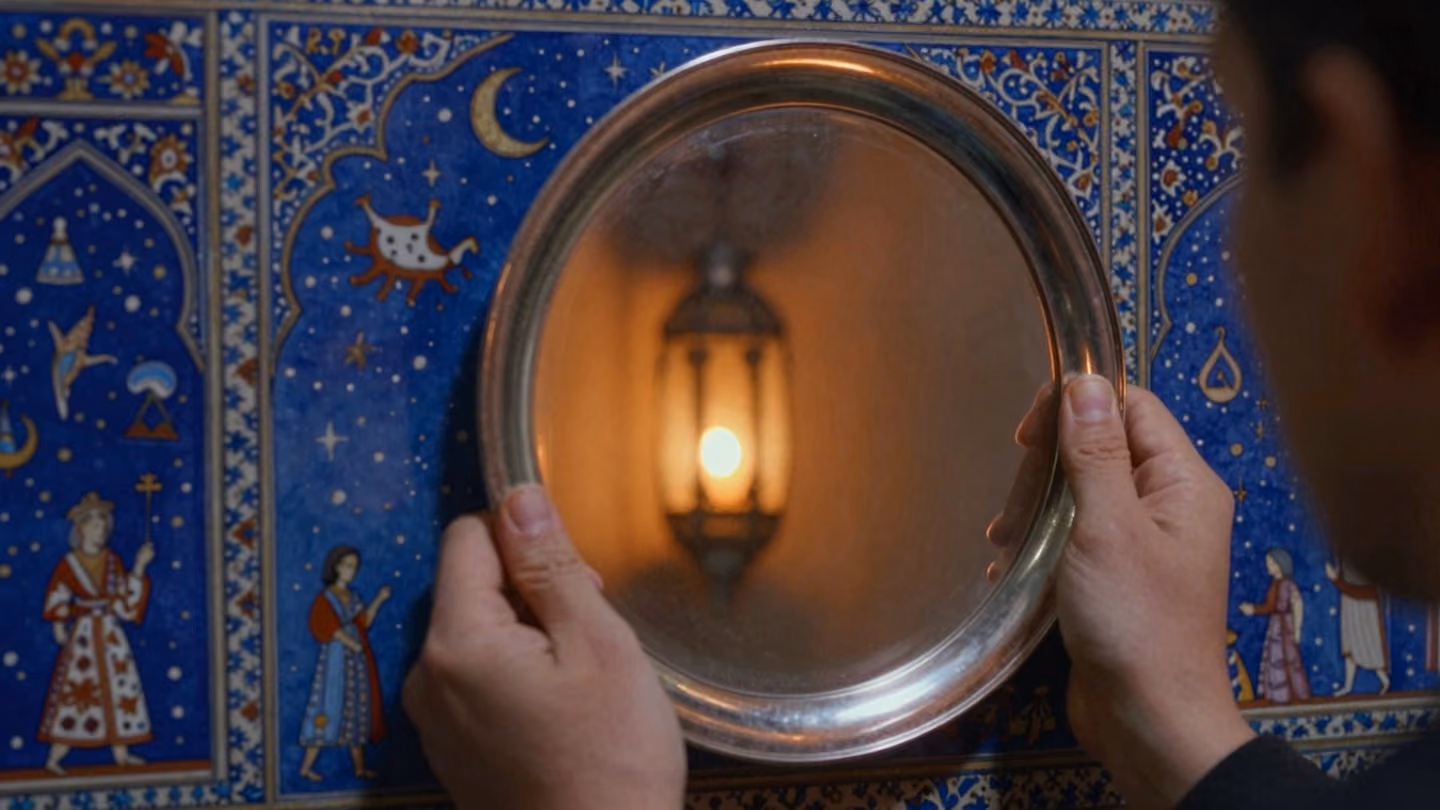 Detail shot of two hands holding a polished silver mirror that reflects only the dim amber glow of a distant lantern, creating a sense of intimate, silent anticipation.