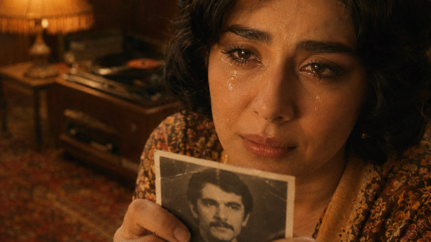 Extreme close-up of the same graceful 30-year-old Iranian woman's face as she holds a faded black-and-white photograph in her hands inside a warm walnut-paneled 1970s living room, tears glistening on her cheeks, a Per…